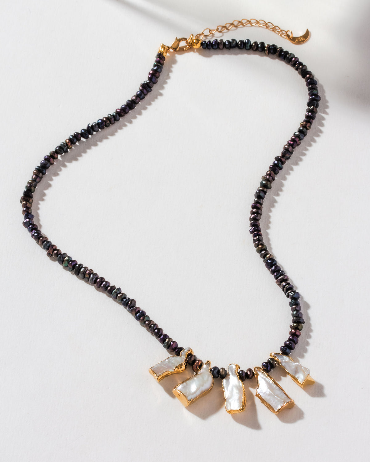 Necklace featuring iridescent pearl beads and five gold-plated keshi pearl pendants.