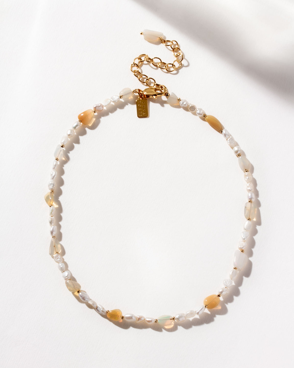 Necklace featuring freshwater pearls and interspersed iridescent opal beads.