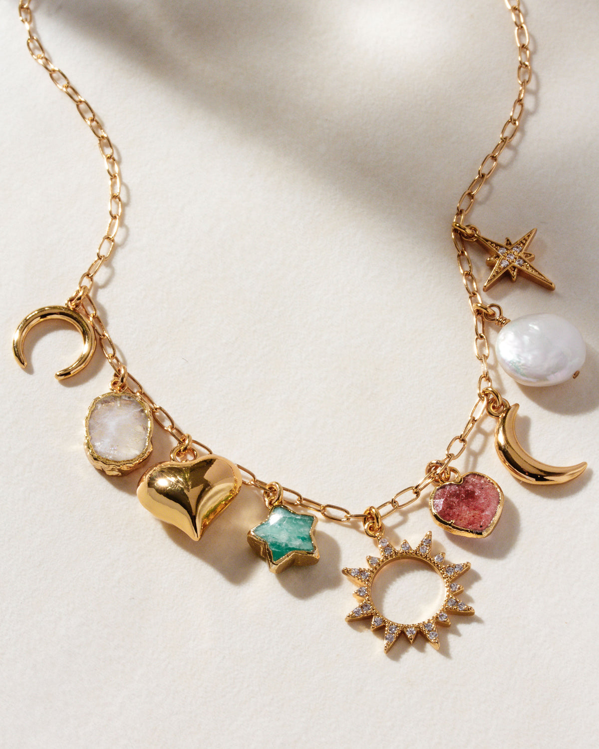 Gold necklace with rainbow moonstone, amazonite star, strawberry quartz heart, and coin pearl