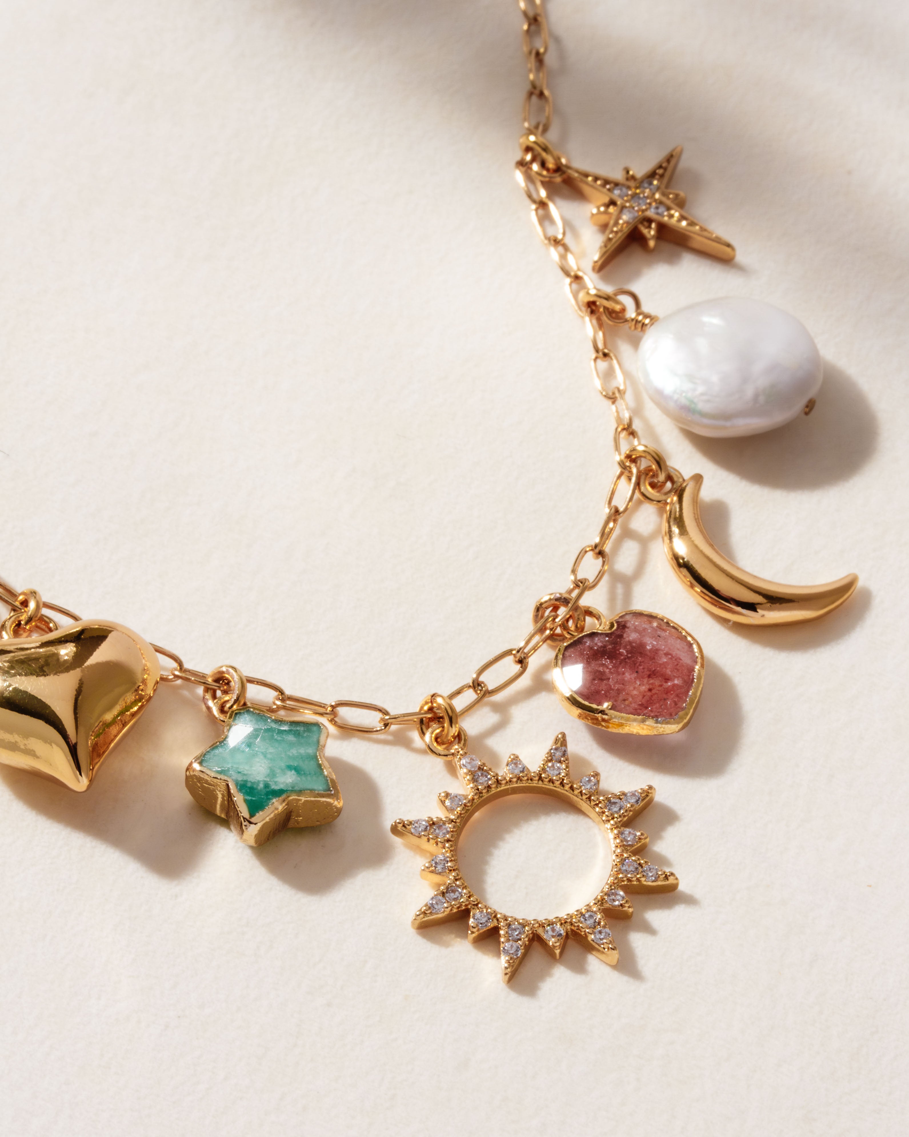 Gold necklace with rainbow moonstone, amazonite star, strawberry quartz heart, and coin pearl