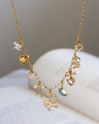 Gold necklace with various charms on a white surface