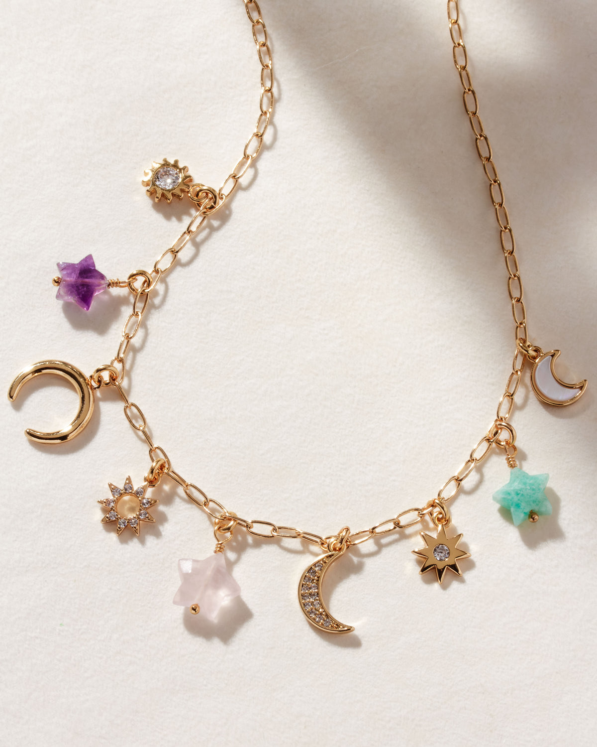 Starlit Trail Charm Necklace with Amethyst, Onyx, and Multistone charms on a gold paperclip chain.