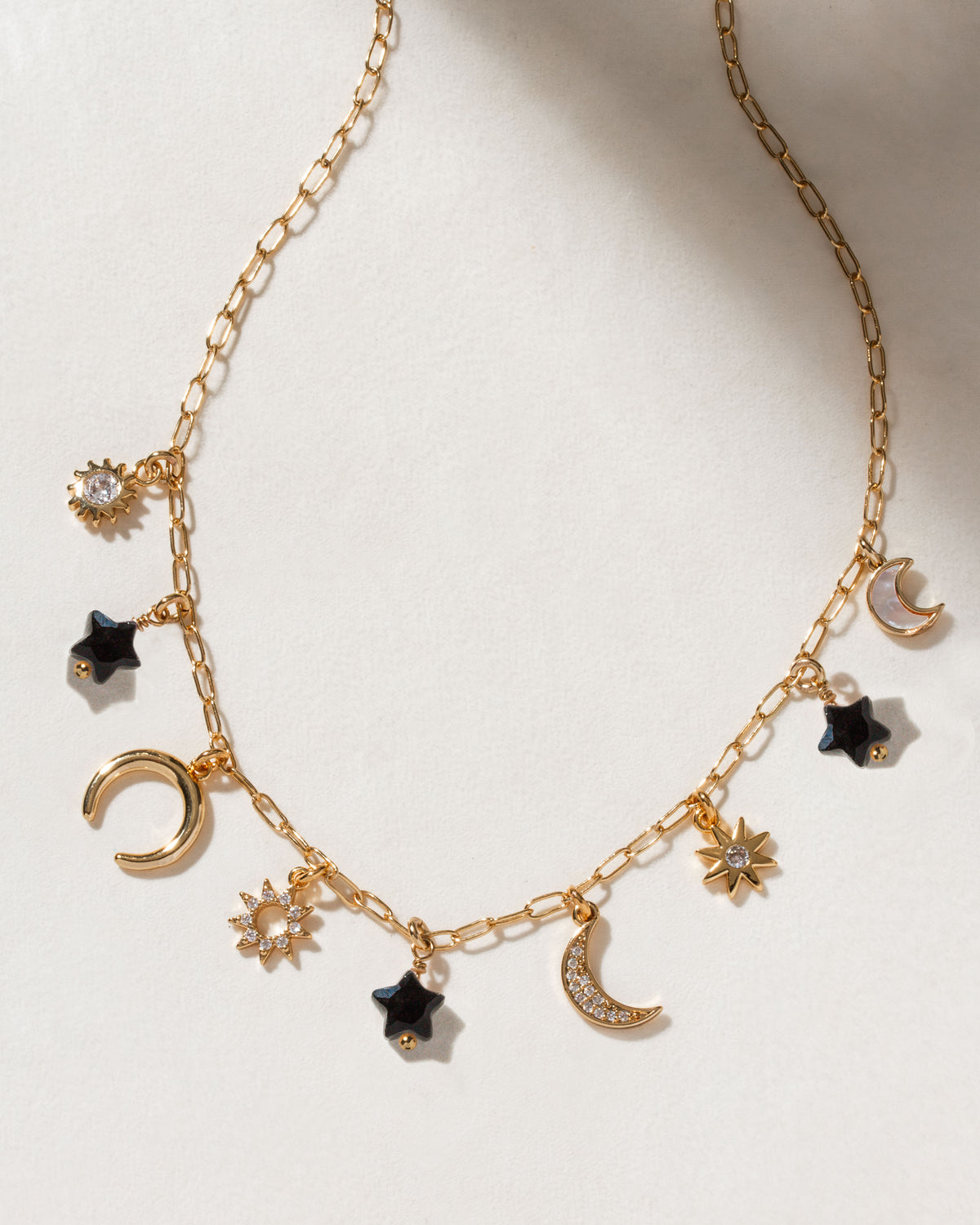 Starlit Trail Charm Necklace with gold chain and Black Onyx charms.