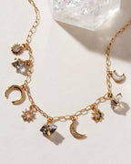 Gold charm necklace with Herkimer quartz, mother-of-pearl, and celestial charms