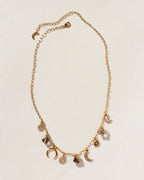 Gold charm necklace with black onyx, Herkimer quartz, moonstone, and celestial charms