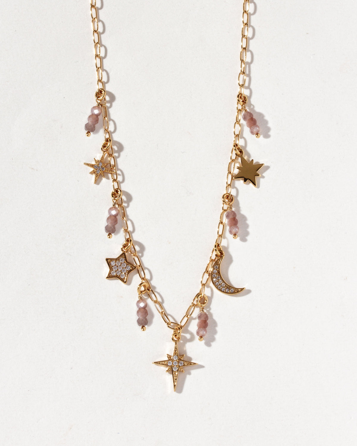 Gold necklace with coffee moonstone drops, star and moon charms, and CZ accents