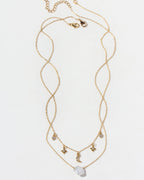 Gold necklace with star and moon charms on a white background