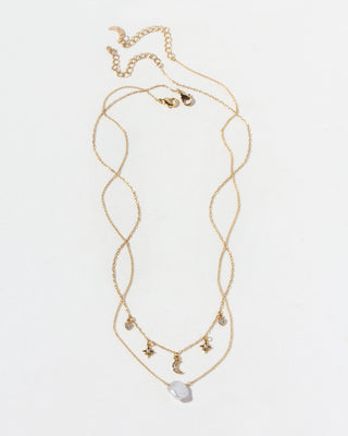 Gold necklace with star and moon charms on a white background