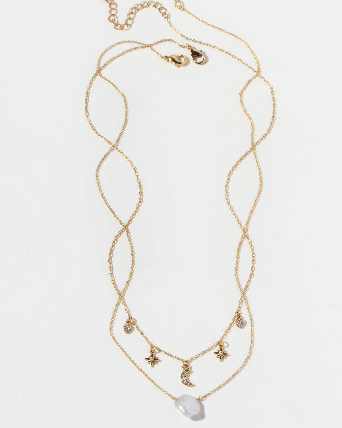 Gold necklace with star and moon charms on a white background