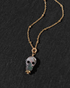 A gold chain necklace featuring a skull pendant.