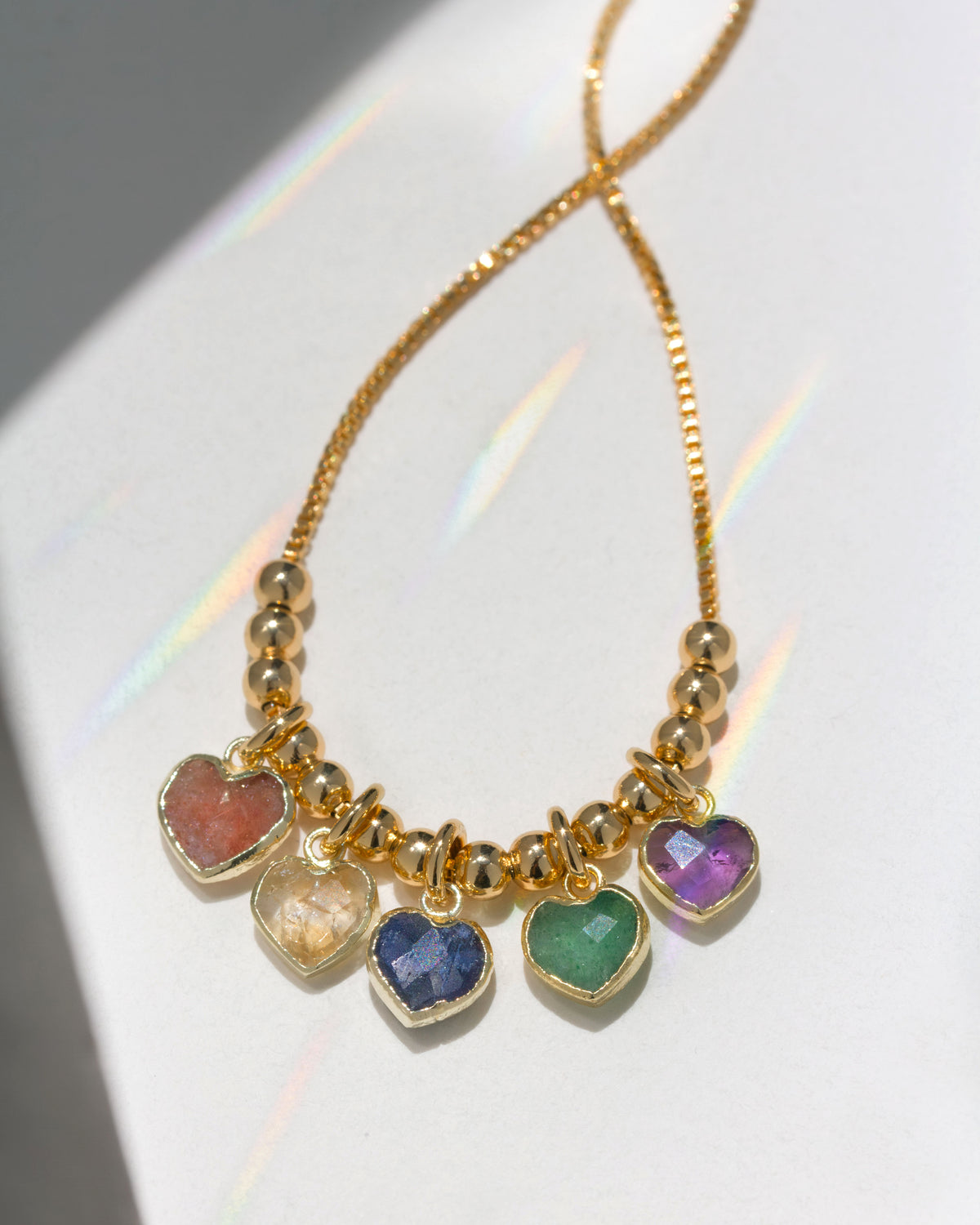 Gold necklace with strawberry quartz, citrine, sapphire, aventurine and amethyst heart charms.