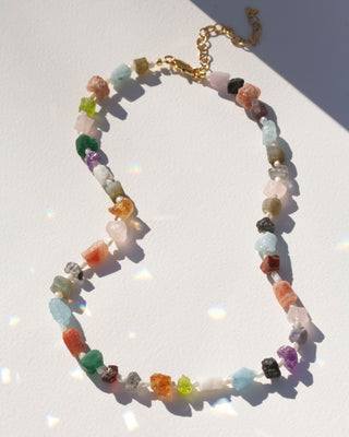 Multicolored multi-stone beaded necklace on a white background