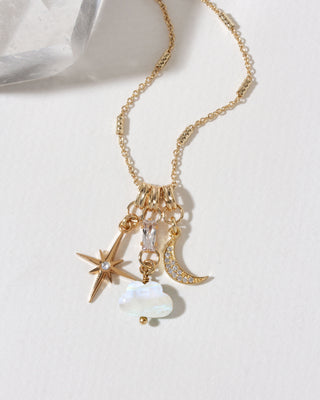 A gold-toned charm necklace featuring a Polaris star, crescent moon, genuine moonstone cloud, and clear CZ accents.