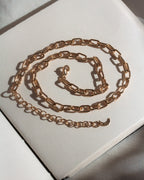 Gold chain necklace on a light gray background
