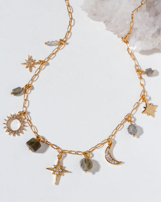 Gold necklace with cz celestial charms on a light background