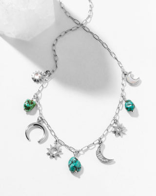 Necklace with moon, star, and turquoise charms on a white background