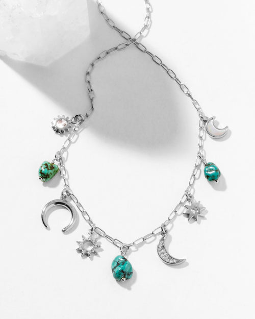 Necklace with moon, star, and turquoise charms on a white background
