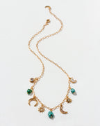 Gold necklace with many charms on a white background