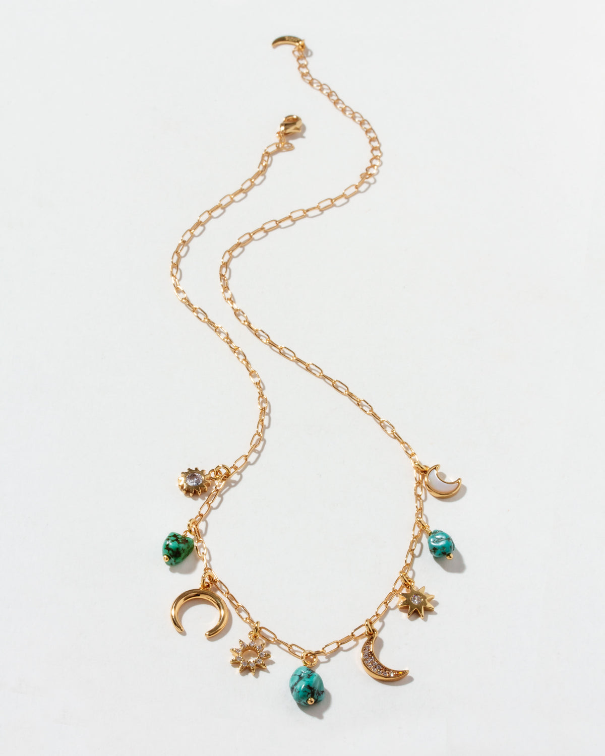 Gold necklace with many charms on a white background