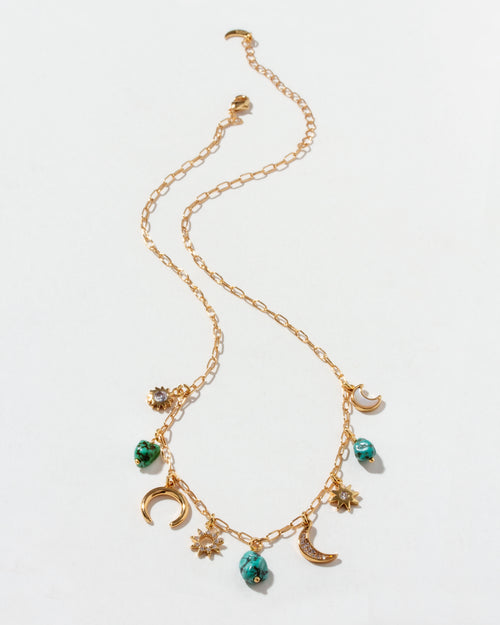 Gold necklace with many charms on a white background