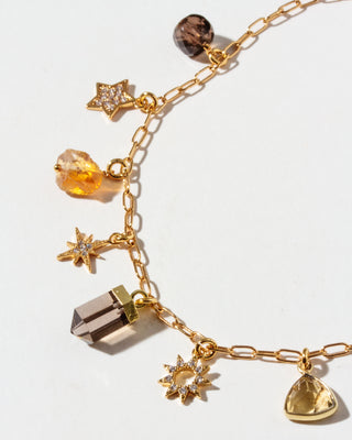 Gold necklace with various CZ, Smoky Quartz, and Citrine charms on a white background