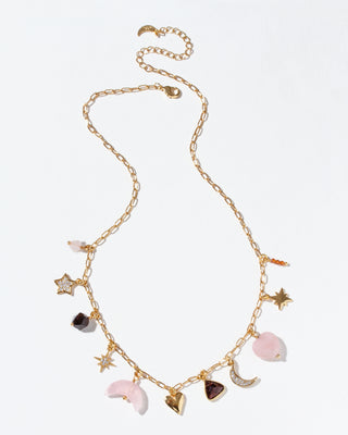 Gold chain necklace with various gemstone charms on a light background