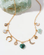 Gold necklace with various CZ, emerald, mother-of-pearl, aquamarine, and pearl charms