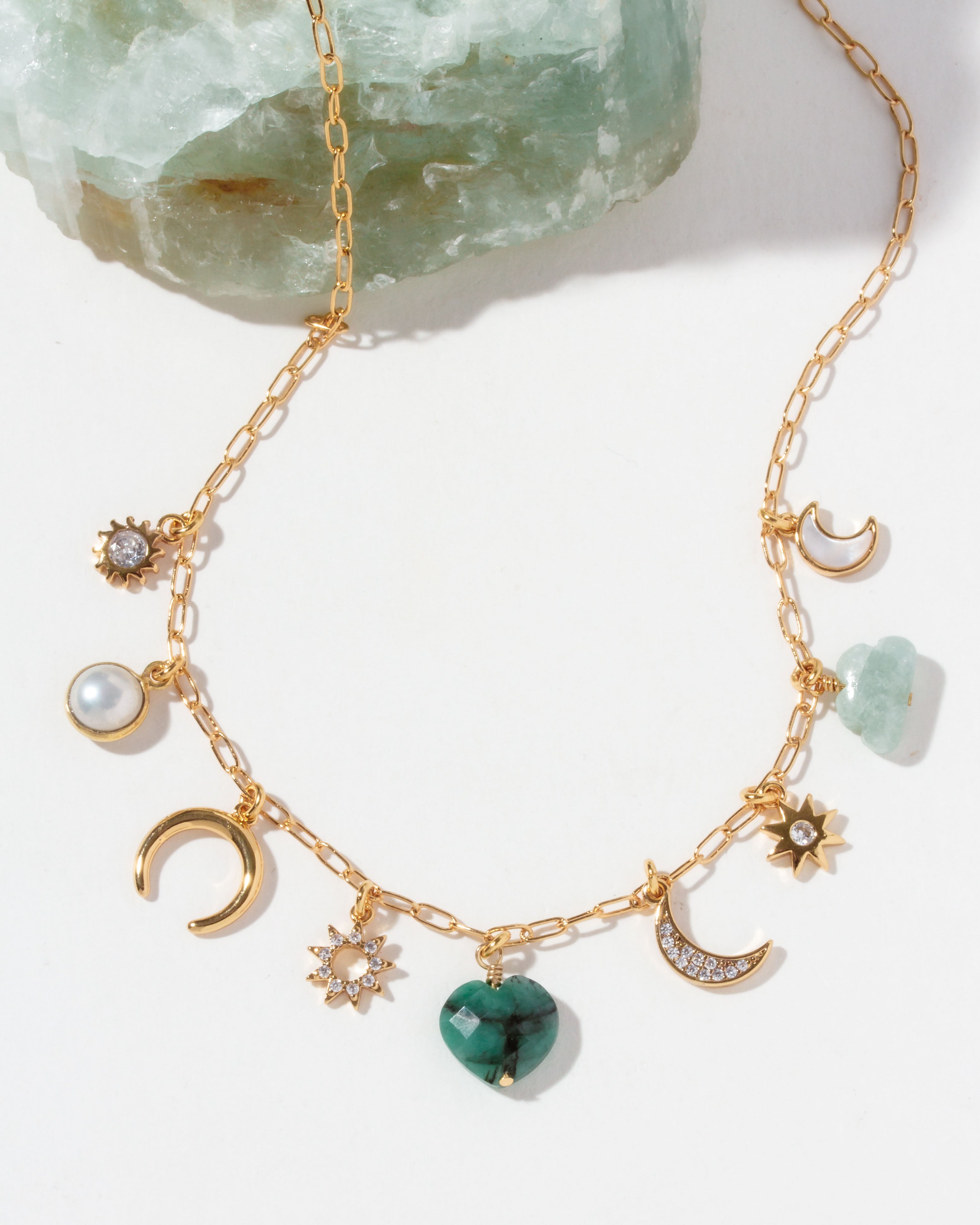 Gold necklace with various CZ, emerald, mother-of-pearl, aquamarine, and pearl charms