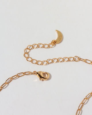 Closeup of gold necklace lobster closure with branded Luna Norte moon shaped tab.