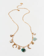 Gold necklace with many different shaped CZ, emerald, mother-of-pearl, aquamarine, and pearl charms