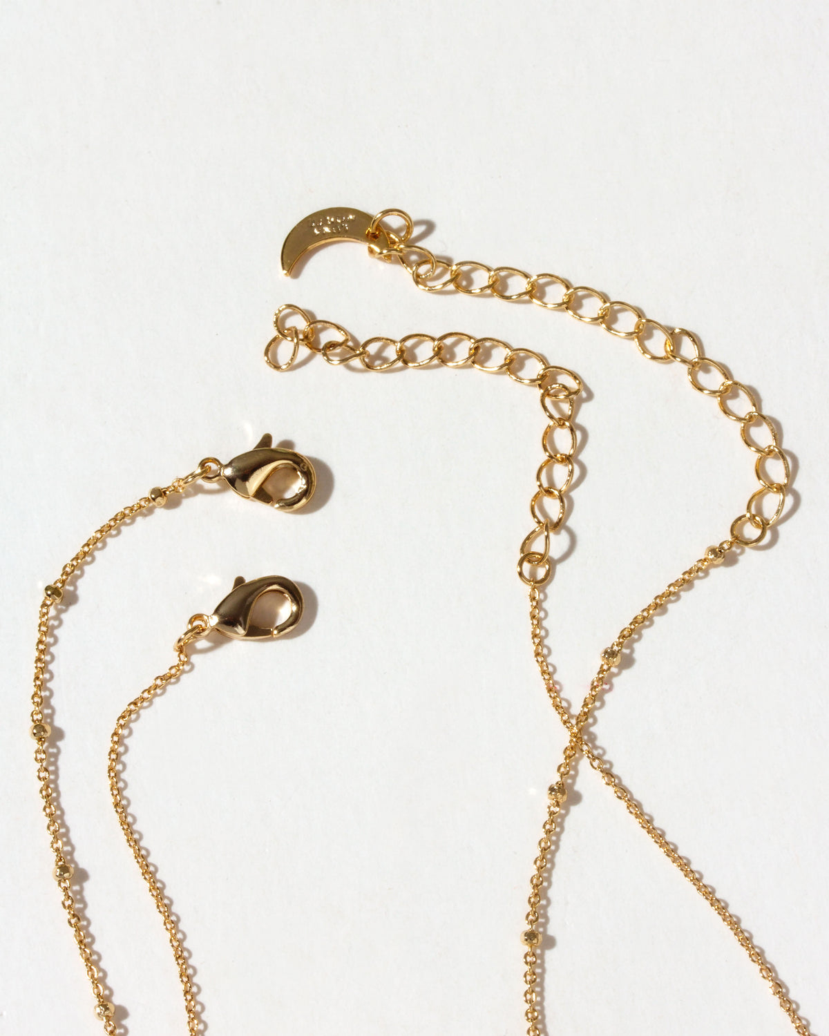 Closeup of Gold chain necklace set lobster clasps on a white background
