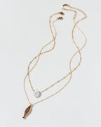Gold necklace set with a fish and keshi pearl pendants on a white background