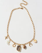 Gold chain necklace with various charms on a light gray background