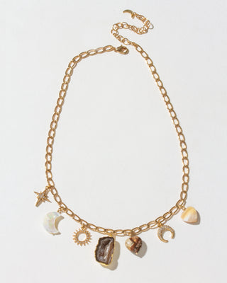 Gold chain necklace with various charms on a light gray background