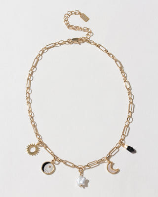 Gold chain necklace with onyx point, pearl star, and sun/moon charms.