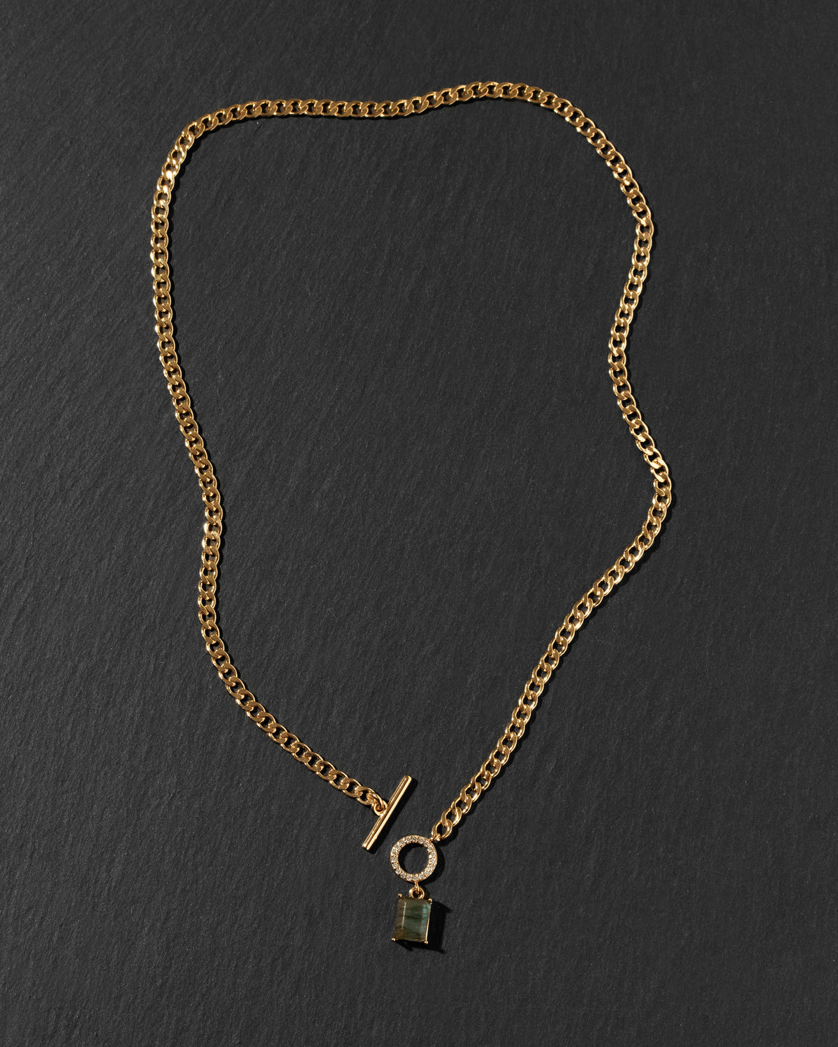A gold-toned chain necklace with a toggle clasp and a small labradorite hanging pendant.