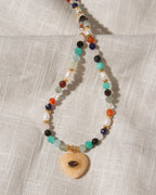 Multicolor faceted gemstone beaded necklace with yellow calcite heart centered with eye shaped CZ center.