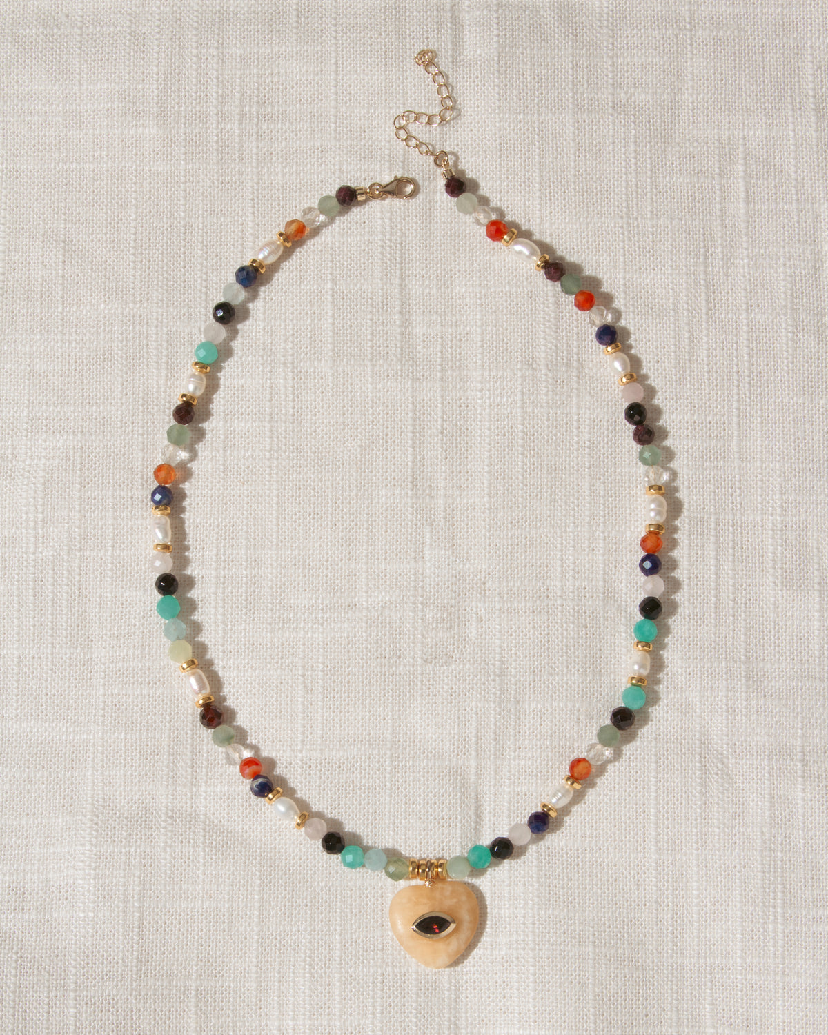 Multicolor faceted gemstone beaded necklace with yellow calcite heart centered with eye shaped CZ center.