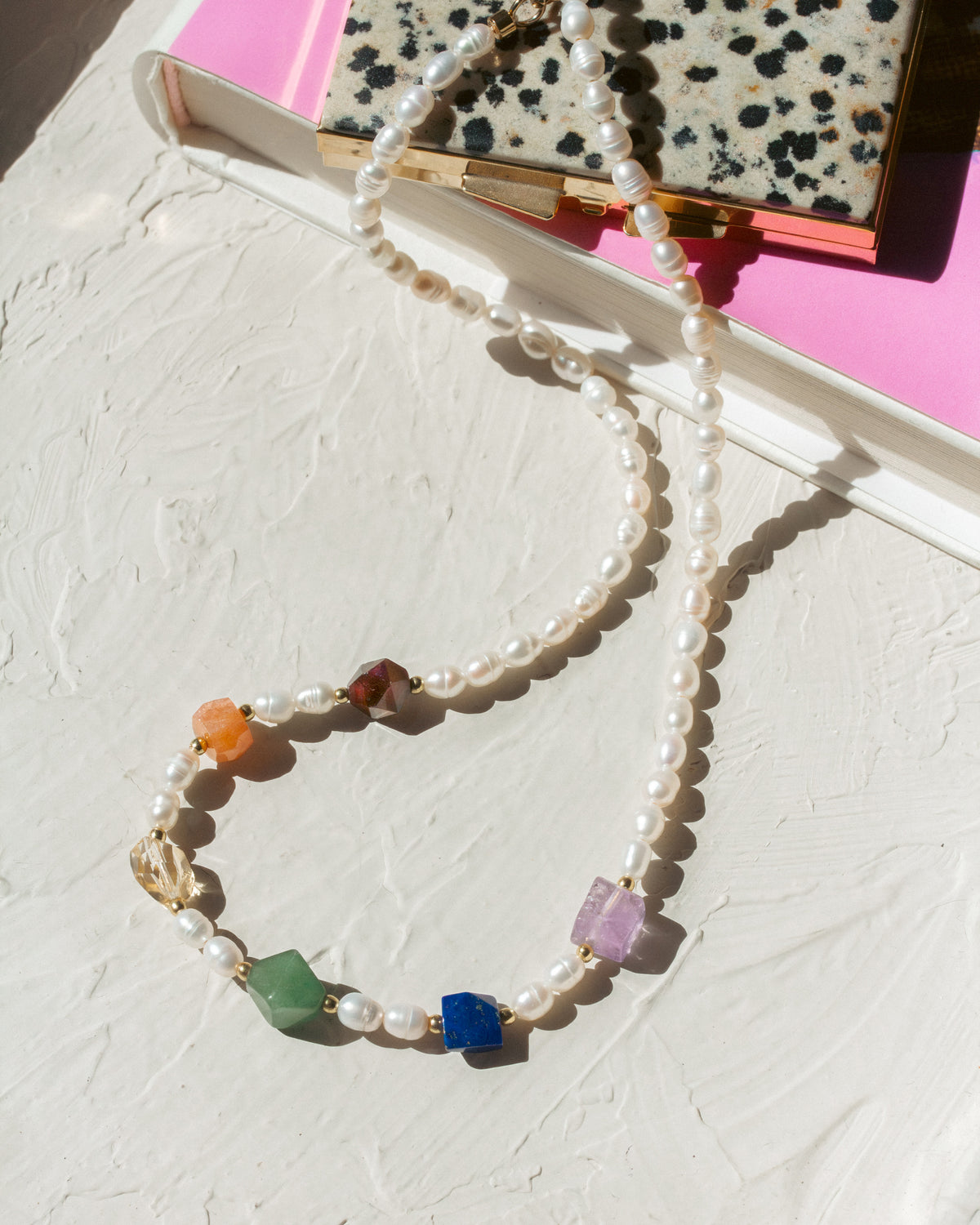 Pearl necklace with colorful beads on a textured surface