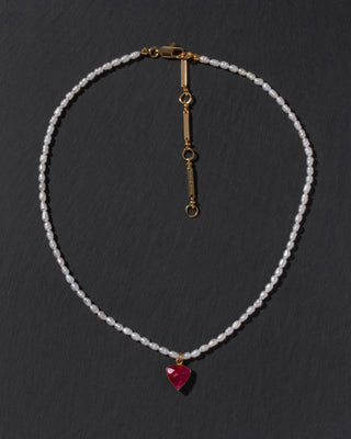 Necklace with a red inverted triangle pendant on a dark background