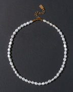 Pearl necklace with a gold clasp on a dark background and no attached charms