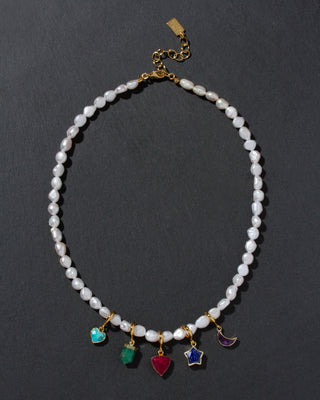 Pearl necklace with colorful charms on a dark background