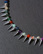 Necklace with spike-like beads and multicolored beads on a dark background