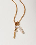 Gold box chain necklace featuring a white baroque pearl, clear crystal, and a gold letter I pendant.