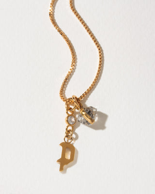 Gold box chain necklace featuring a gothic initial P charm, a small round crystal, and a herkimer quartz crystal pendant.