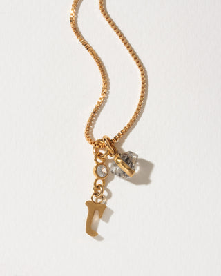 Gold box chain necklace featuring a small bezel-set crystal, a herkimer quartz crystal, and a lowercase letter R charm.