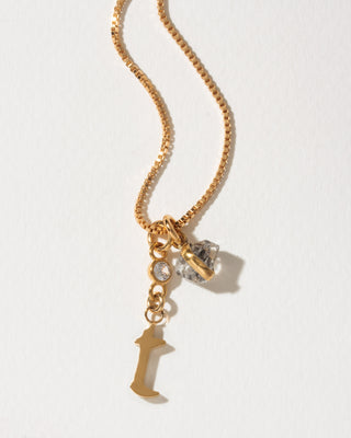Gold box chain necklace featuring a gold letter I initial charm, a small bezel-set crystal, and a herkimer quartz stone pendant.