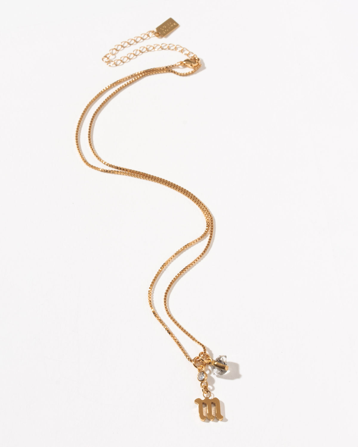 Gold necklace with Gothic letter M charm, crystal, and Herkimer quartz.