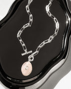 Silver plated paperclip toggle front necklace with pink rose quartz oval pendant with clear center bezeled stone.