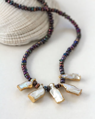Necklace with mother-of-pearl beads and mother of pearl on a light background